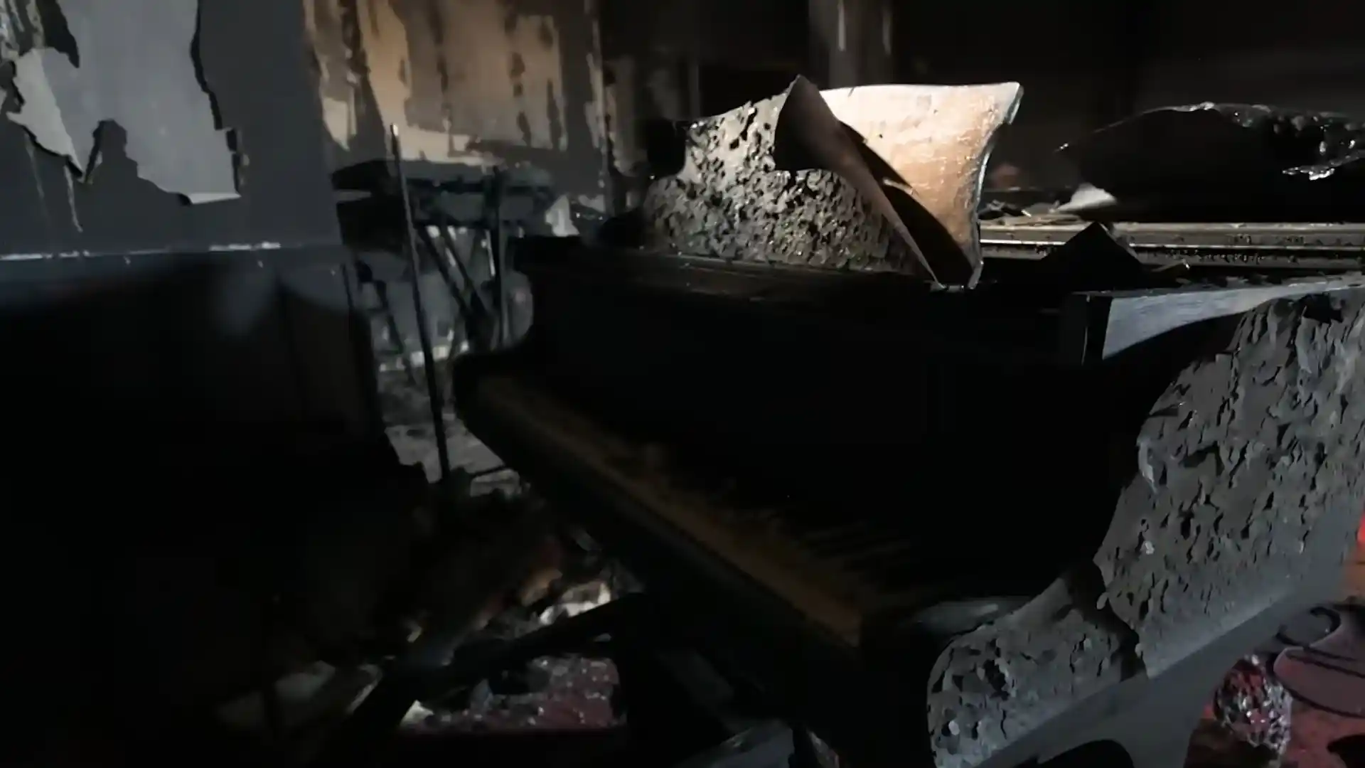 Severely fire-charred piano and furnishings inside a burned commercial interior