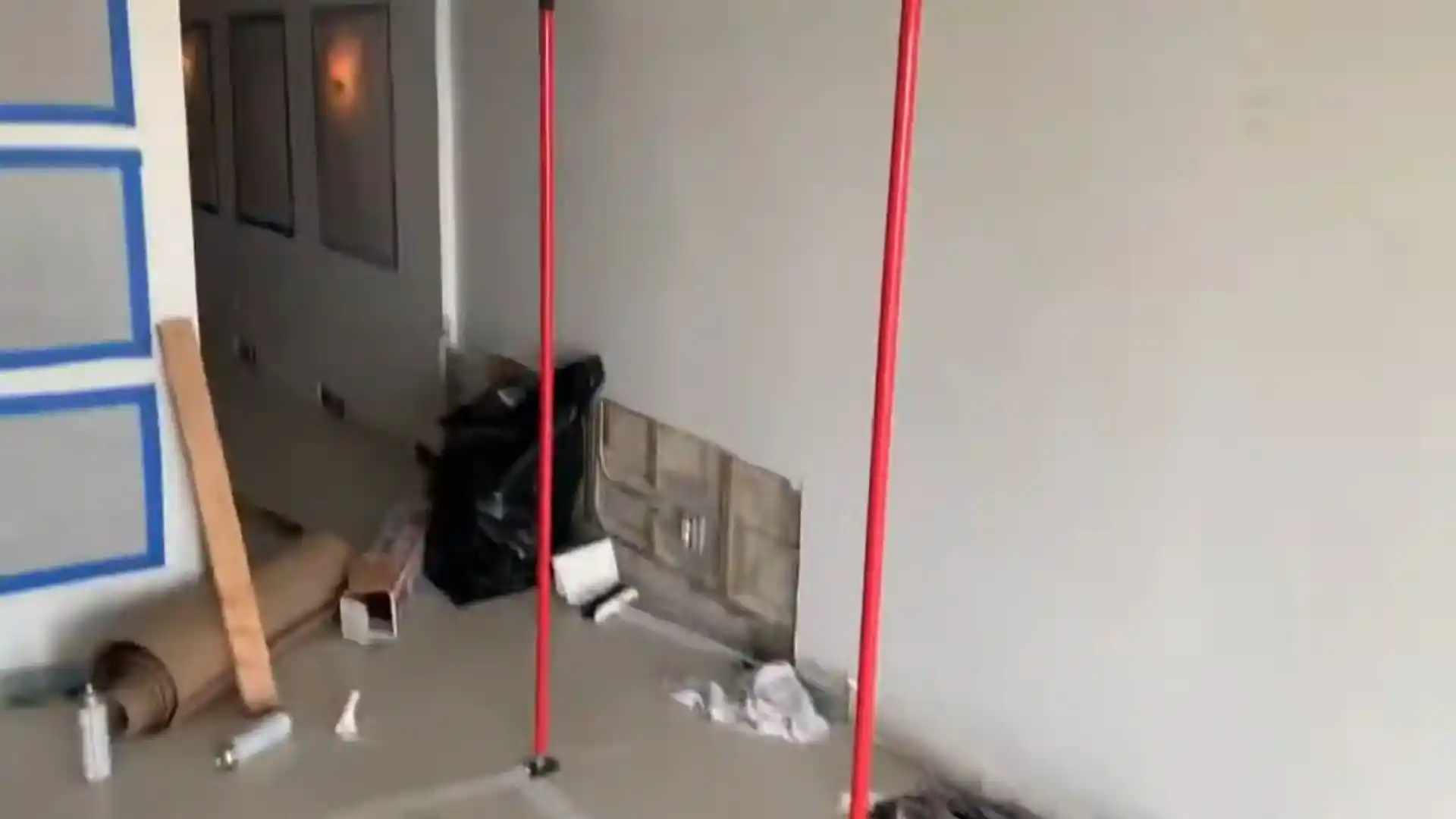 Room mid-restoration with support posts, debris bags, and materials removed from the walls