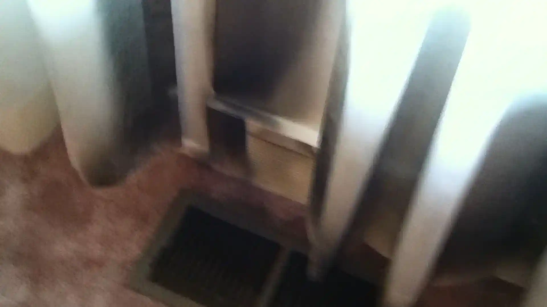 Dim, smoke-darkened room interior near a floor vent after a fire
