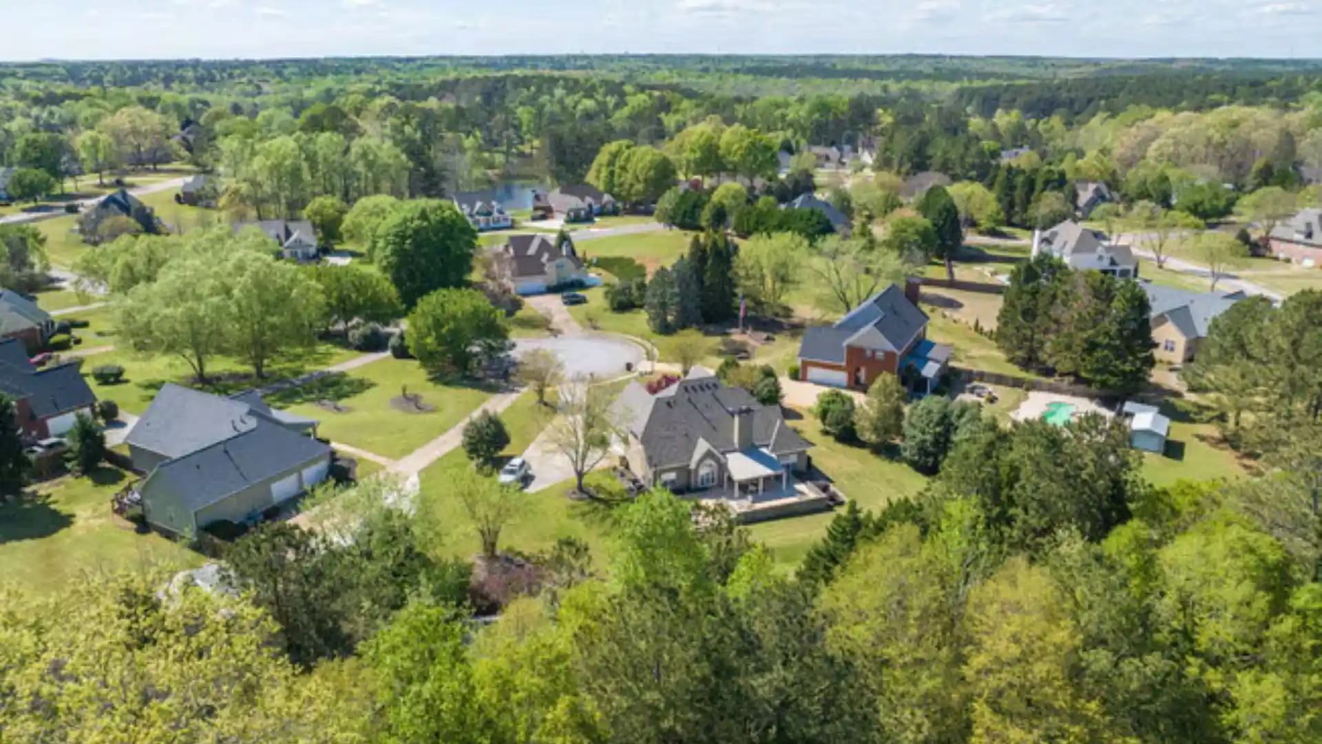 Aerial view of a wooded, low-density residential neighborhood in Tyrone, GA