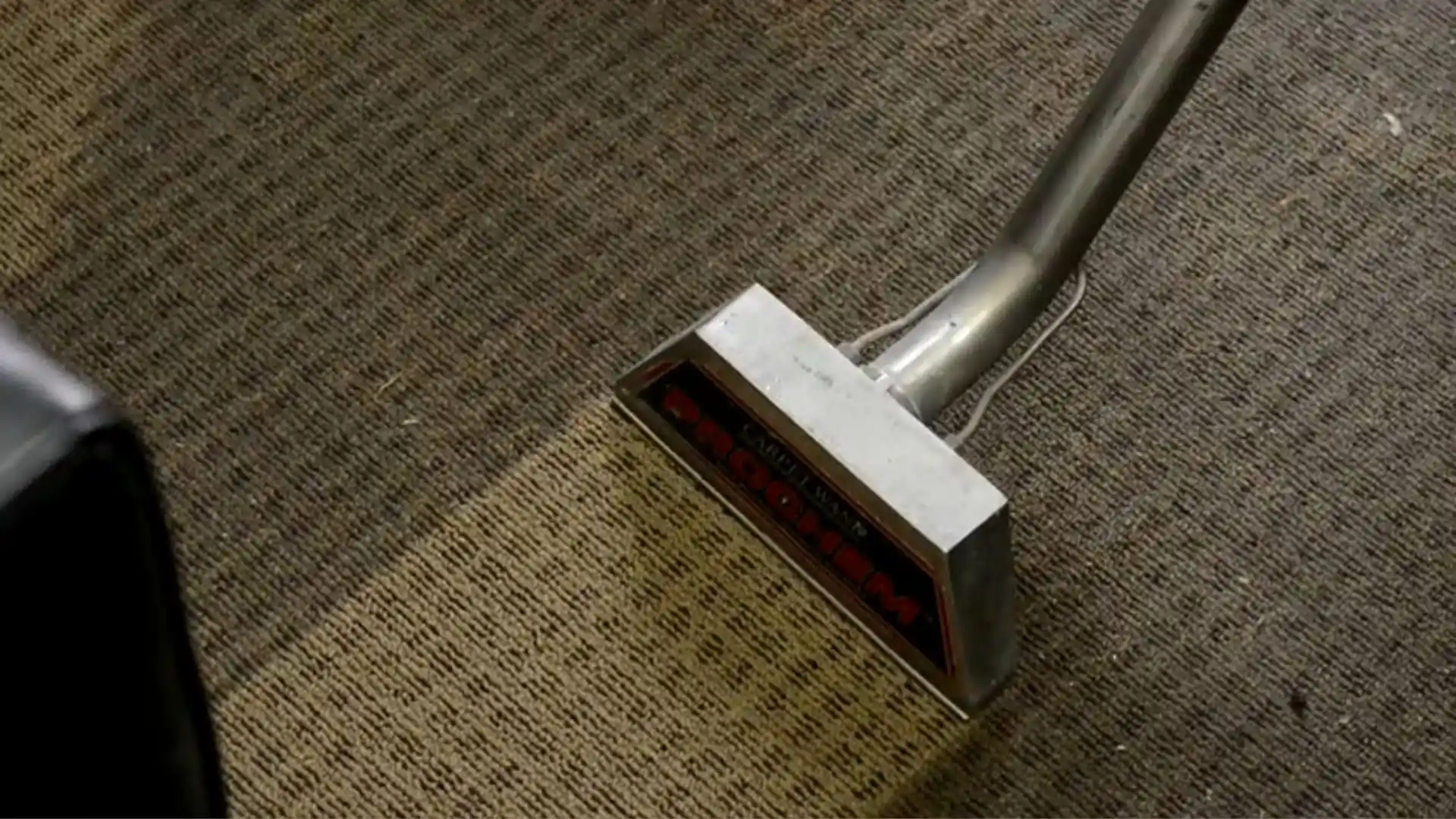 Carpet cleaning wand actively extracting water from a carpeted floor